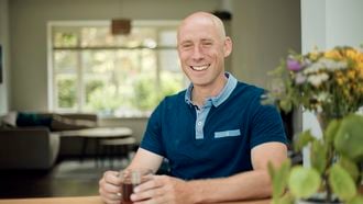 Man zit aan tafel met een kop thee