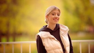 Acelya FAS in bodywarmer in de natuur voor een hekje