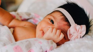 Baby met dikke bos haar en een haarbandje in