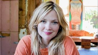 Blonde vrouw met een oranje shirt