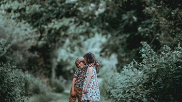 Twee kinderen die dankbaar zijn en elkaar knuffelen