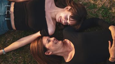 moeder en dochter liggen samen in het gras