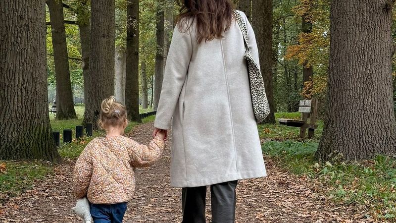 Judith ten Bokkel met haar dochtertje Lara hand in hand wandelend in het bos na periode van rouw en herstel na verlies