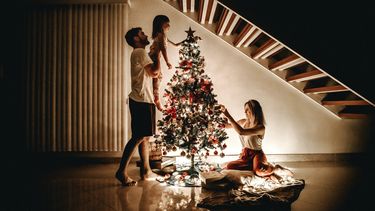 Een gezin dat samen de kerstboom optuigt