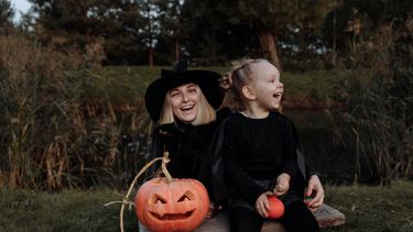 Moeder en dochter verkleed als heksen met pompoenen voor halloween die griezelfilms gaan kijken halloween hapjes