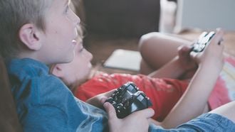 Twee kinderen met een game controller aan het gamen. Onderzoek naar mediagebruik en ADHD