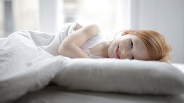 overprikkeld kind ligt in bed