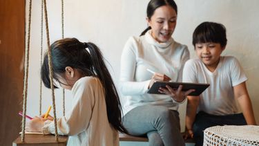 Moeder met haar kinderen die kinderspelletjes spelen