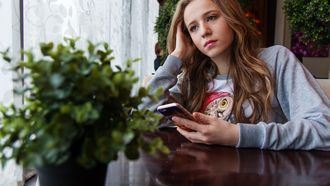 Meisje met smartphone maakt zich zorgen