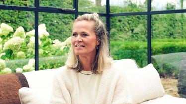 Vrouw kijkt weg in een serre met een groene achtergrond