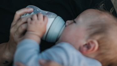kindje krijgt flesvoeding