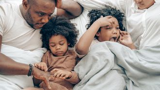Ouders met kinderen in bed, die niet in hun eigen bed willen slapen