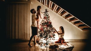 Een gezin dat samen de kerstboom optuigt