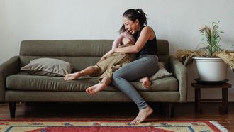 Vrouw knuffelt haar zoon op de bank en heeft een-op-een tijd